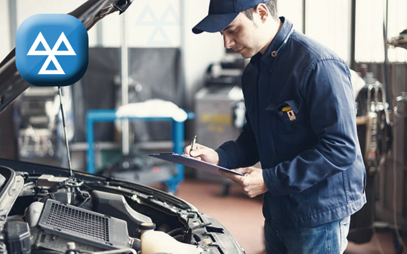 Neil Arnold Tyres And Autos Mechanic inspecting car engine during MOT test, checking clipboard.